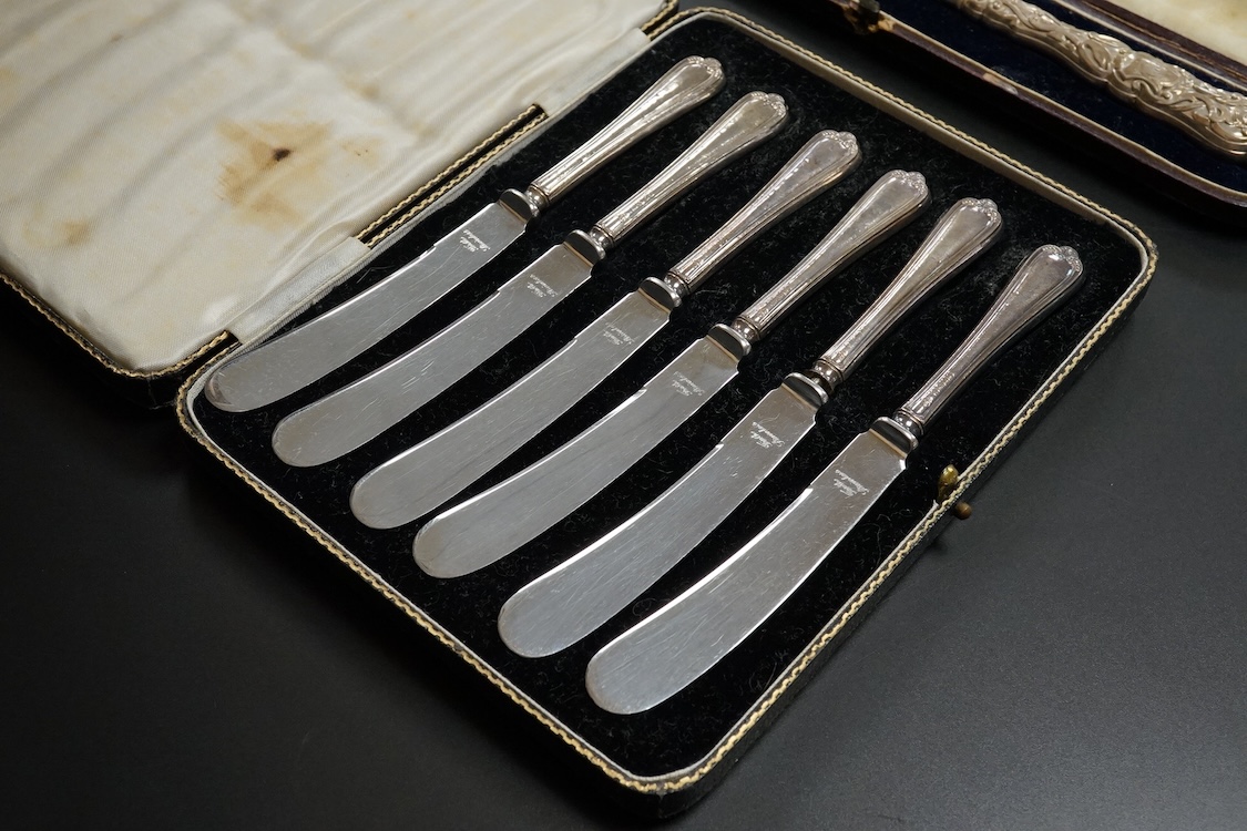A cased set of twelve Edwardian silver apostle teaspoons with a pair of sugar tongs, Cooper Brothers & Sons, Sheffield, together with a cased Victorian silver bread knife and a cased set of six silver handled steel tea k